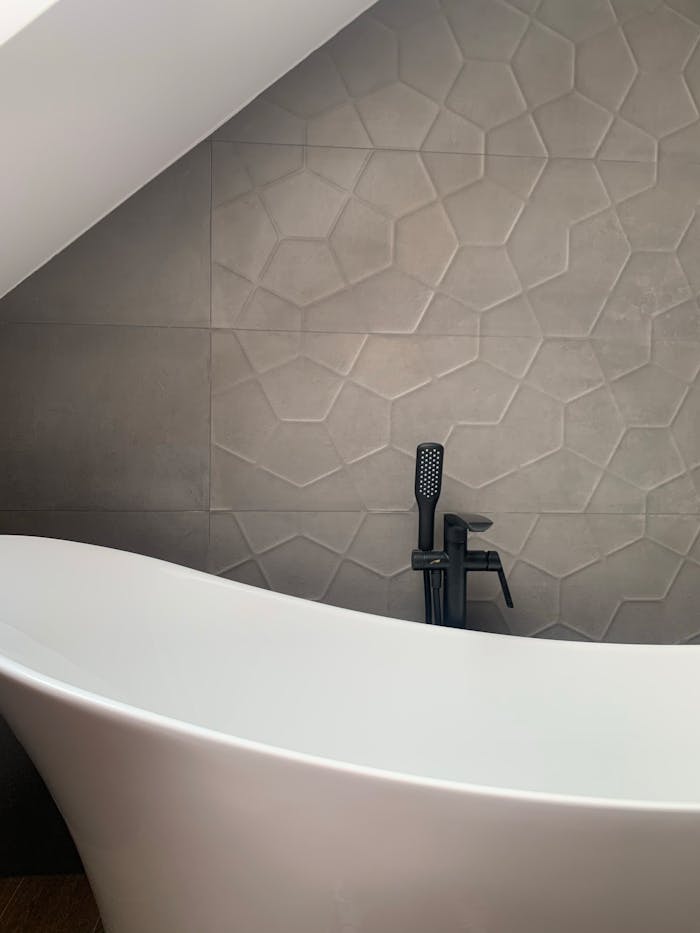 Mastering the First Impression: Your intriguing post title goes here Stylish black shower and faucet near curvy white bathtub in modern light mansard bathroom